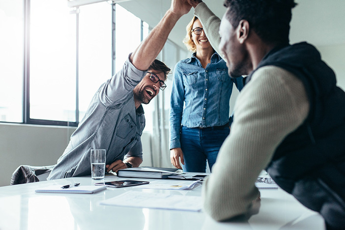 5 Steps I Used to Launch My Real Estate Investing Career Two colleagues giving high five in meeting. Business people celebrating success in conference room.