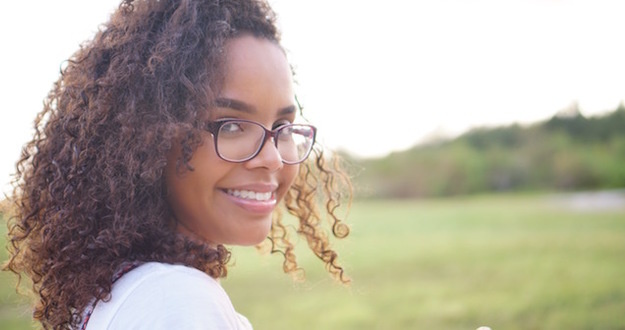 How I Made More Than $130,000 Profit on a $183,900 Purchase dark curly haired pretty woman in glasses smiling outdoors