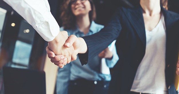 How Do You Cash Out a Sandwich Lease? Young business people shaking hands in the office. Finishing successful meeting. Three persons