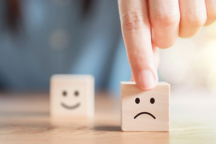 Point-Counterpoint: Debt Is Bad When It Comes to Real Estate Close up customer hand choose sad face and blurred smiley face i