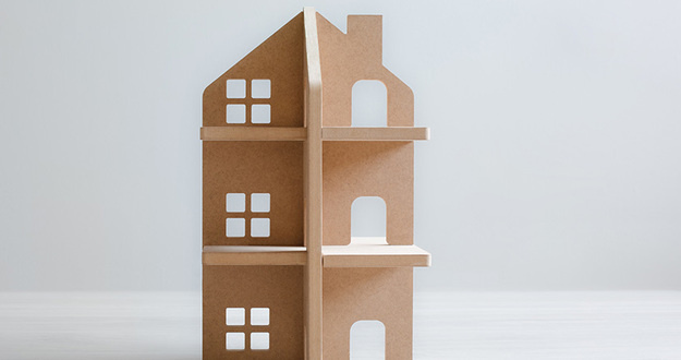 The Ultimate Guide to Multifamily Financing wooden model of multifamily property on gray background