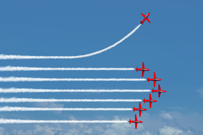 Be Weird—Because Truly Successful (& Rich!) People Think and Act Differently Than Everyone Else Charting a different path business concept as an independent free thinker idea with air show jet airplanes in an organized formation with one individual plane setting a new course with 3D illustration elements.