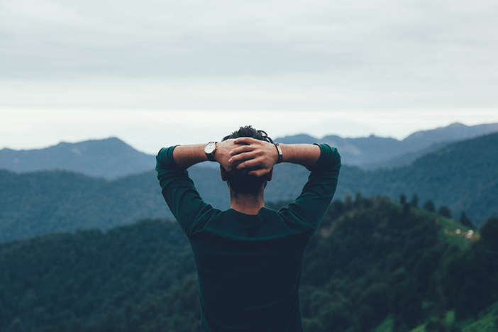 1031 Exchange: How to Find a Replacement Property—Fast man facing away from camera looking out at mountain range