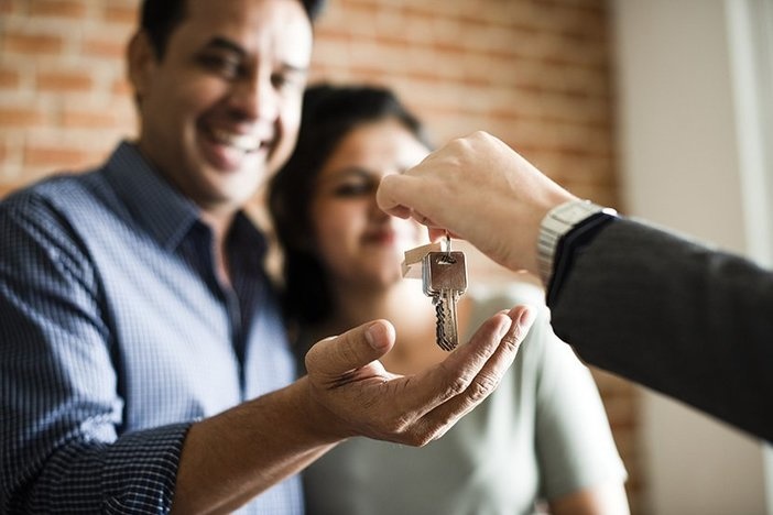 6 Easy Ways To Simplify Your First Home Purchase Cheerful couple receiving keys to their new home