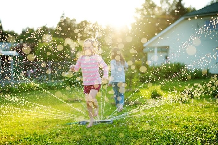 Meet the Investors: Finding More Time for Family Through Real Estate Investing Featuring Jon Kessler Adorable little girls playing with a sprinkler in a backyard on sunny summer day. Cute children having fun with water outdoors. Funny summer games for kids.