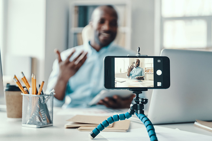 Why Live Video Is the Quickest Path To Authentic Marketing Handsome young African man in shirt telling something and smiling while making social media video