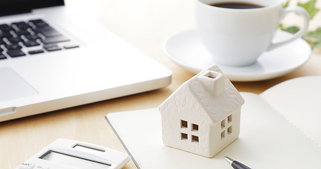 Rent to Own Homes: How to Profit from a Lease Purchase wooden model of house on desk with coffee cup, calculator, laptop