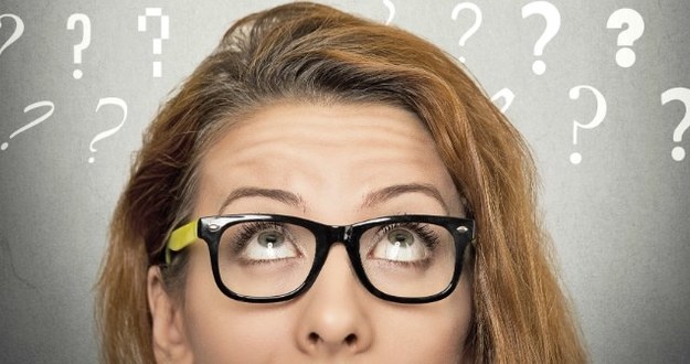 6 Questions to Ask Yourself at the Year’s End for a Better Business in 2015 top half of red haired woman's head with blackboard in background question marks written in chalk