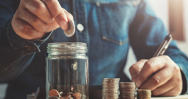 3 Smart Ways to Make an Extra $1,000 a Month hand puting coins into jug glass for saving money finance and accounting concept