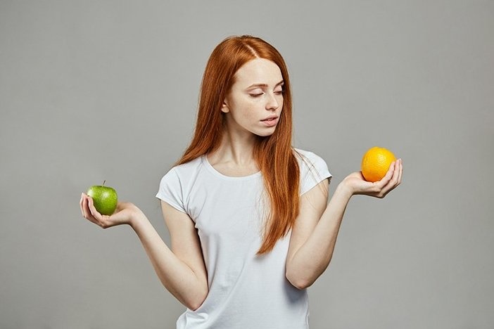 The Ultimate Guide to Quickly Estimating a Property’s ARV (After Repair Value) red haired caucasian woman comparing apples and oranges.