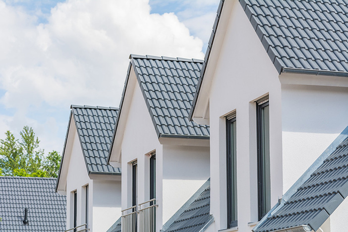 4 Rules of 1031 Exchanges Every Investor Should Know close up view of upper level windows and roofs on four row homes