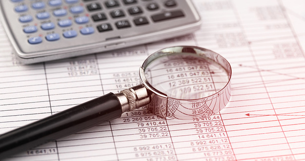 4 Tips for Hiring the Right CPA for Your Real Estate Business spreadsheet, calculator and magnifying glass on desktop